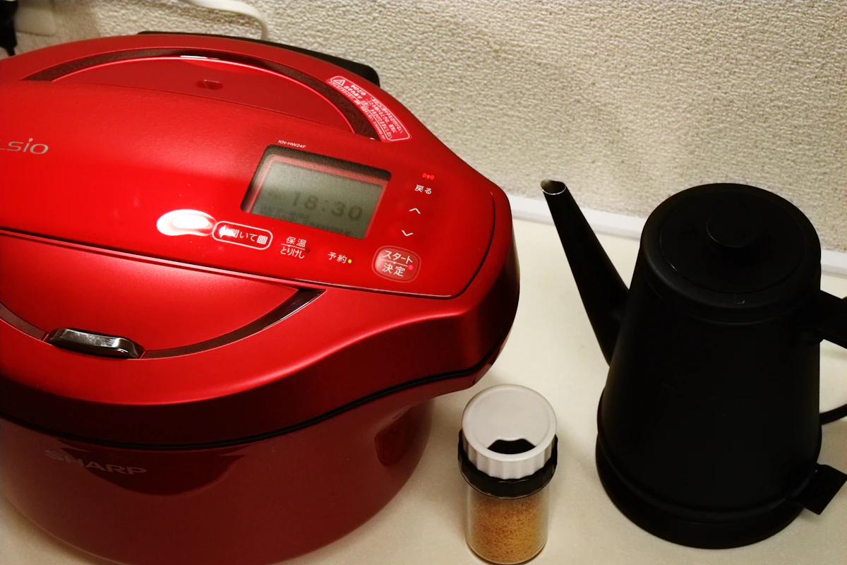 Robot cuiseur multifonction rouge avec écran de programmation posé sur un plan de travail