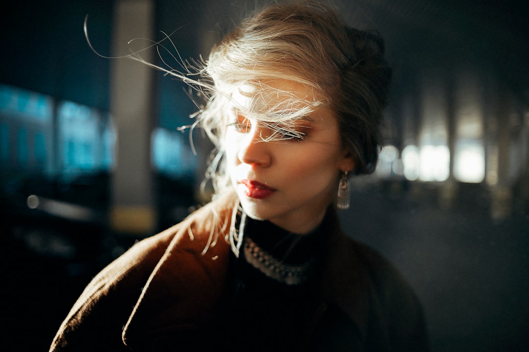 woman in black coat with white and black scarf