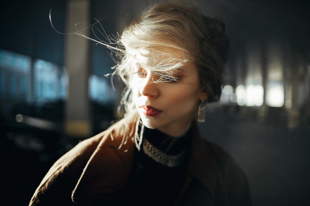 woman in black coat with white and black scarf