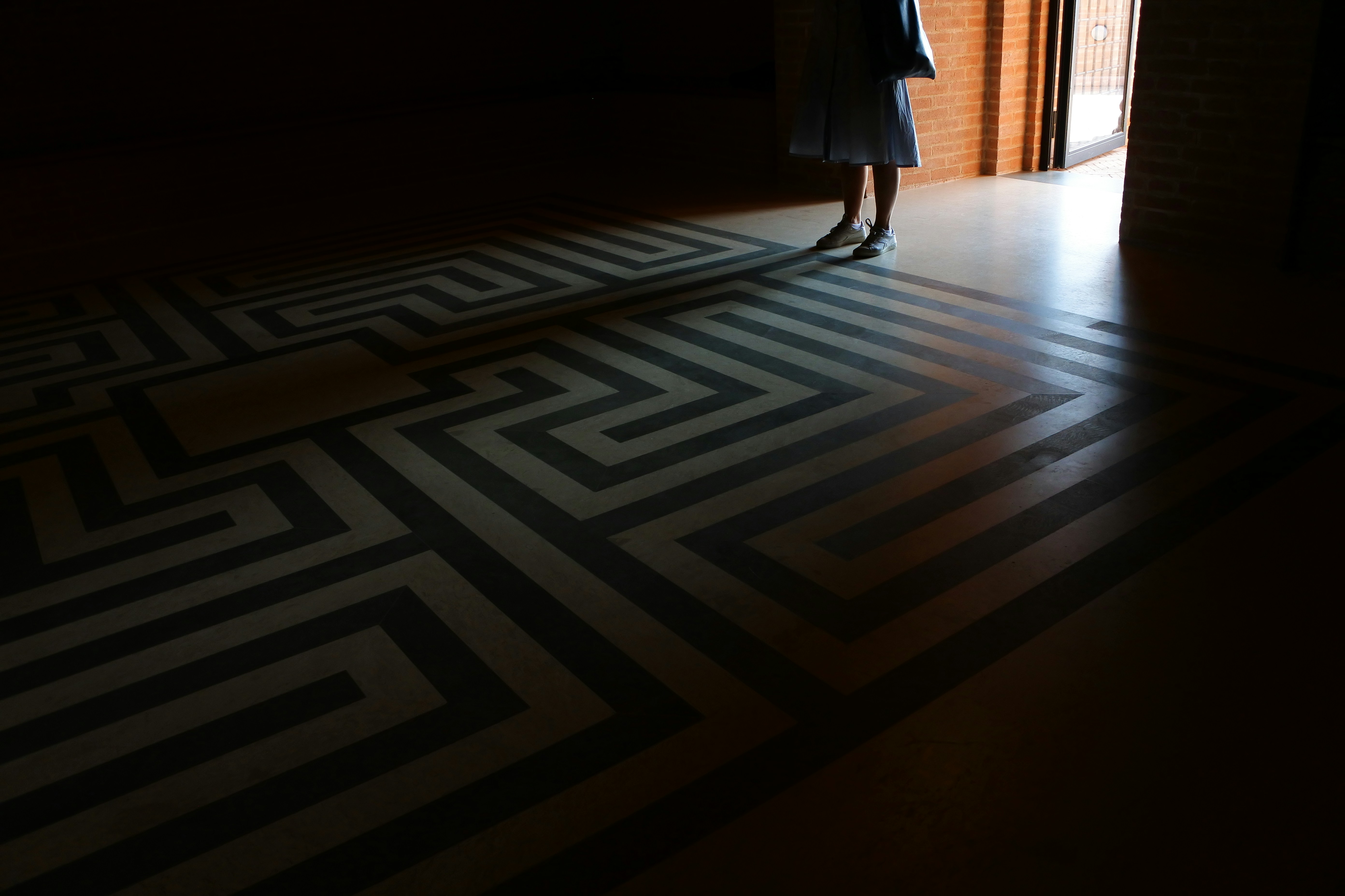 woman in black dress standing on black and white chevron floor