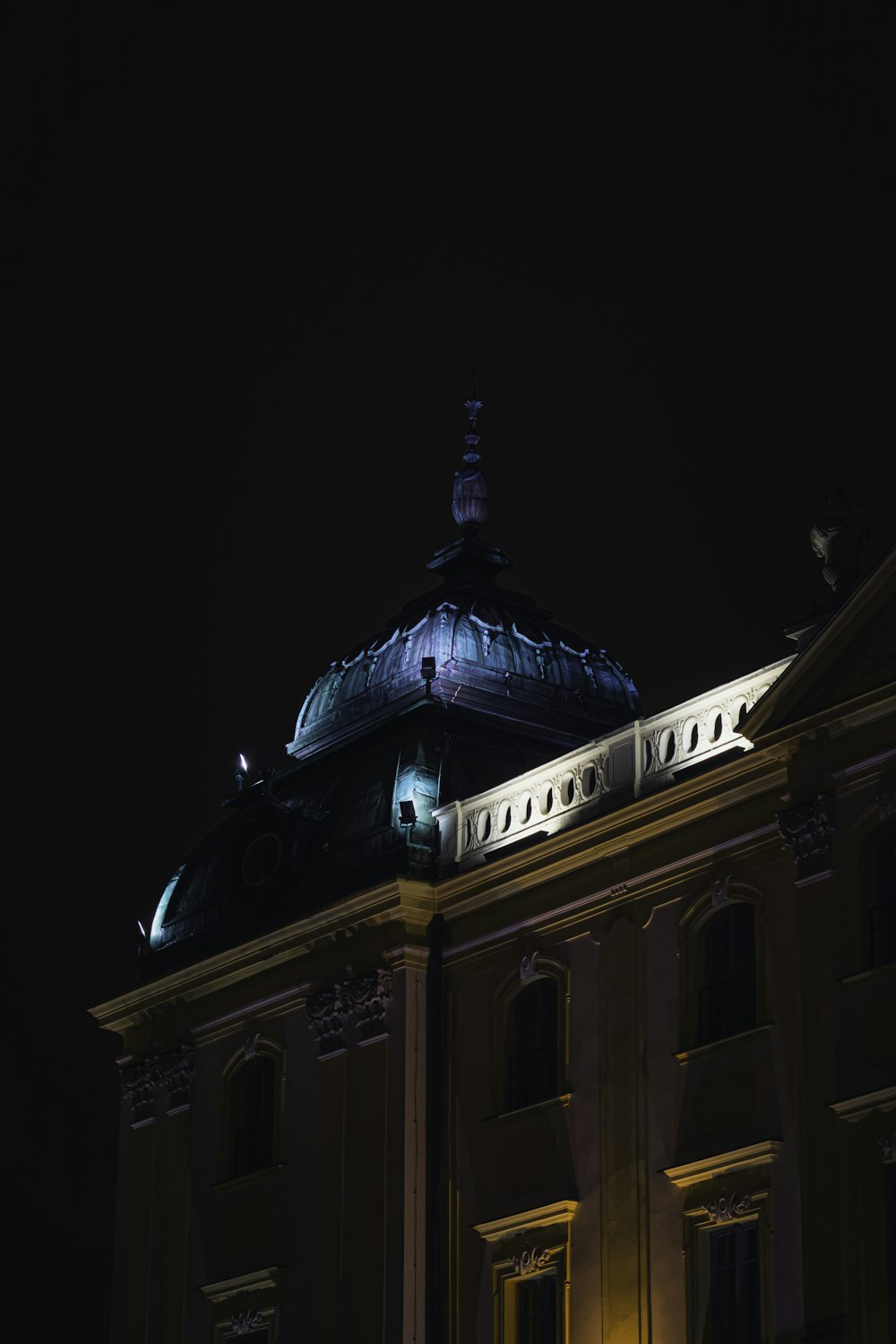 Edificio de hormigón marrón y azul durante la noche