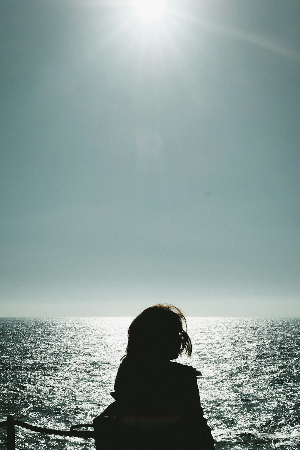 woman in black jacket standing near body of water during daytime