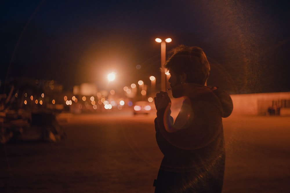 man in black shirt holding lighted candle during night time