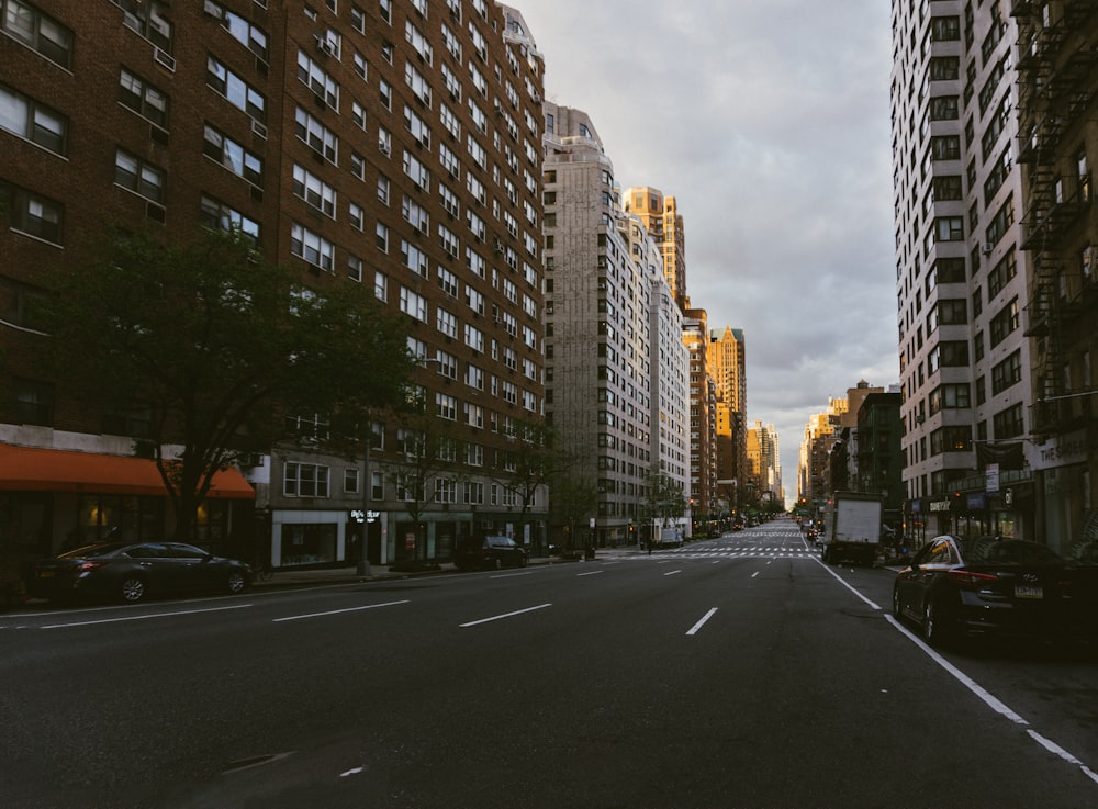 gray concrete road between high rise buildings during daytime