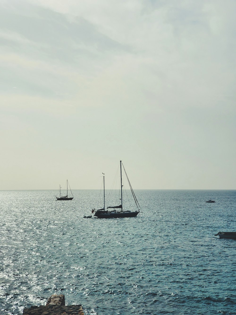 sailboat on sea under white sky during daytime