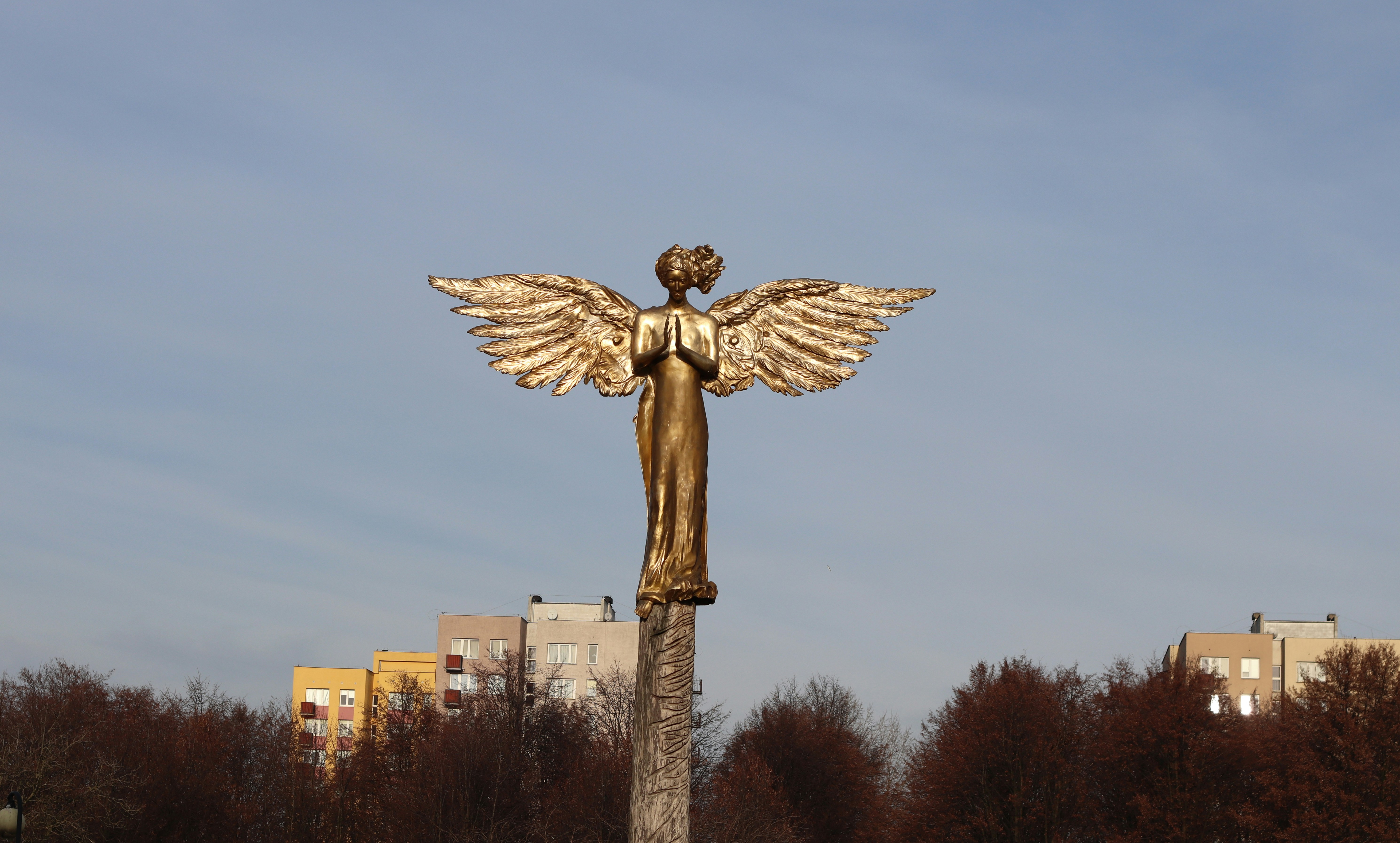 brown concrete statue under gray sky