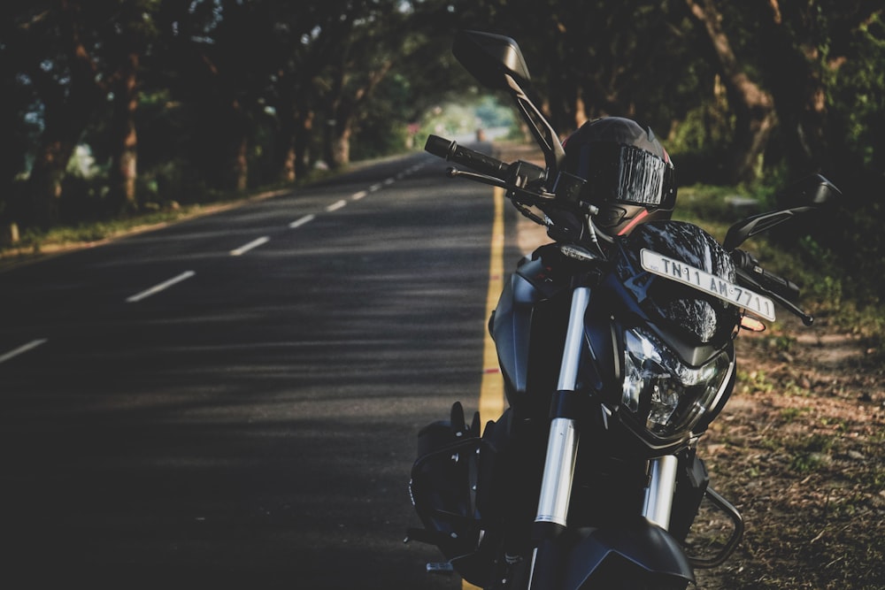 man in black helmet riding motorcycle on road during daytime