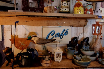 A cozy display of handcrafted home décor items including wooden signs and pottery on a rustic shelf.