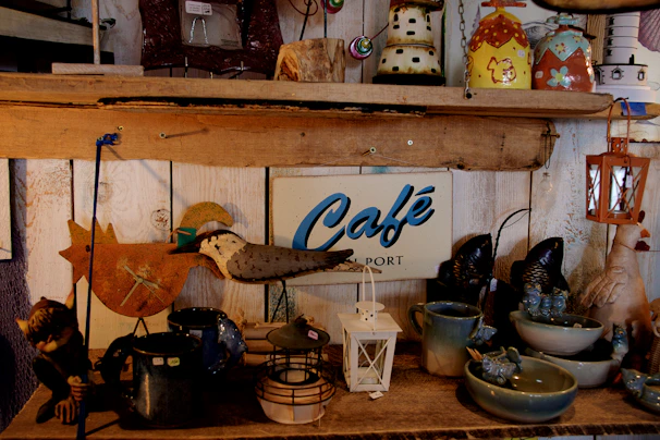 A cozy wooden shelf displaying personalized coastal-themed mugs and small driftwood photo frames.