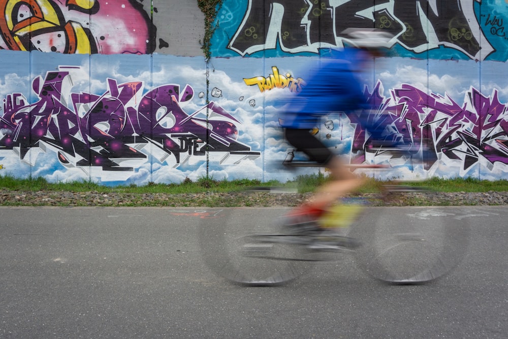 Fille en chemise bleue et short rose à vélo sur la route pendant la journée