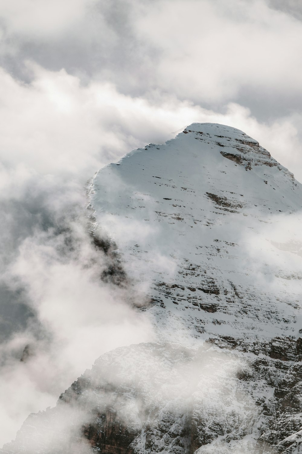 Montagna bianca e grigia sotto nuvole bianche durante il giorno