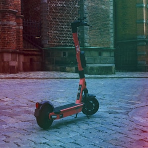 black and red kick scooter on brown concrete floor