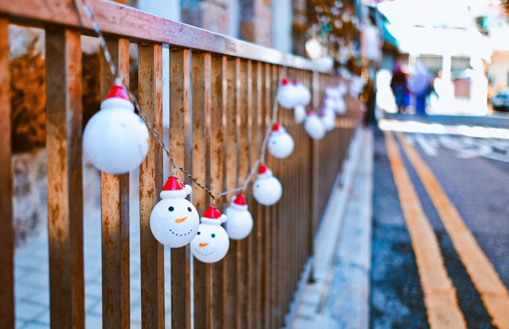 white snowman ornament on brown wooden fence during daytime