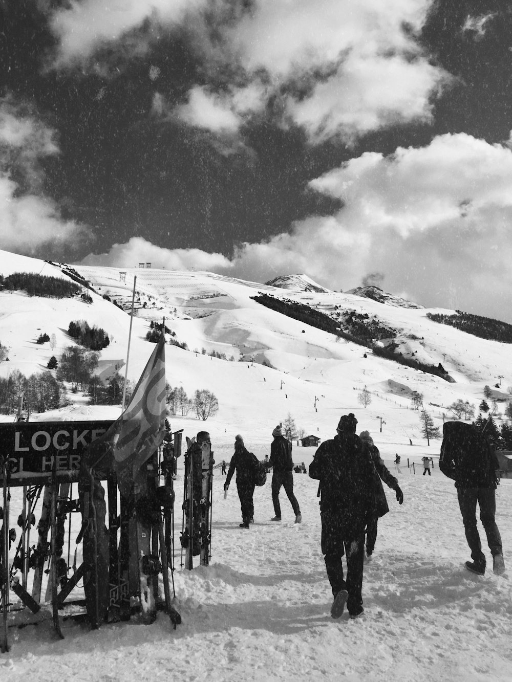 grayscale photo of people standing on snow covered ground