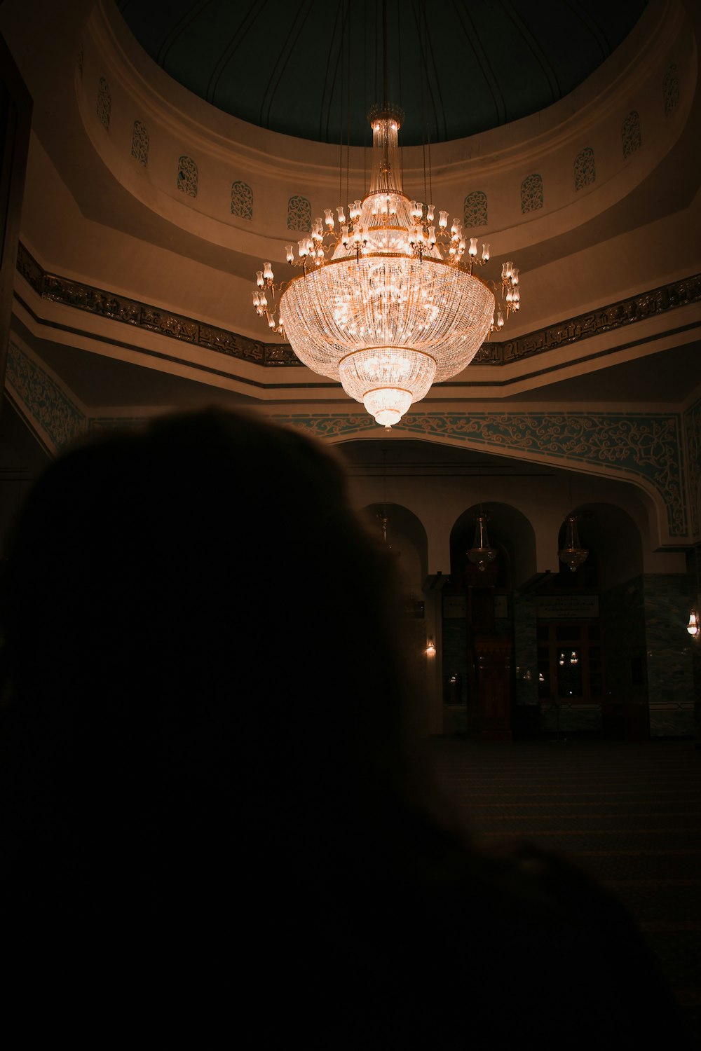 white and gold chandelier turned on in a room