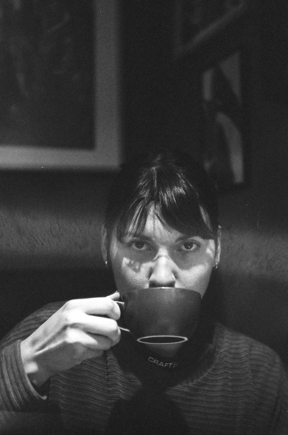 Photo en niveaux de gris d’une femme tenant une tasse en céramique