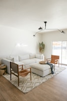 A modern metal-legged sofa with plush cushions in a cozy living room.