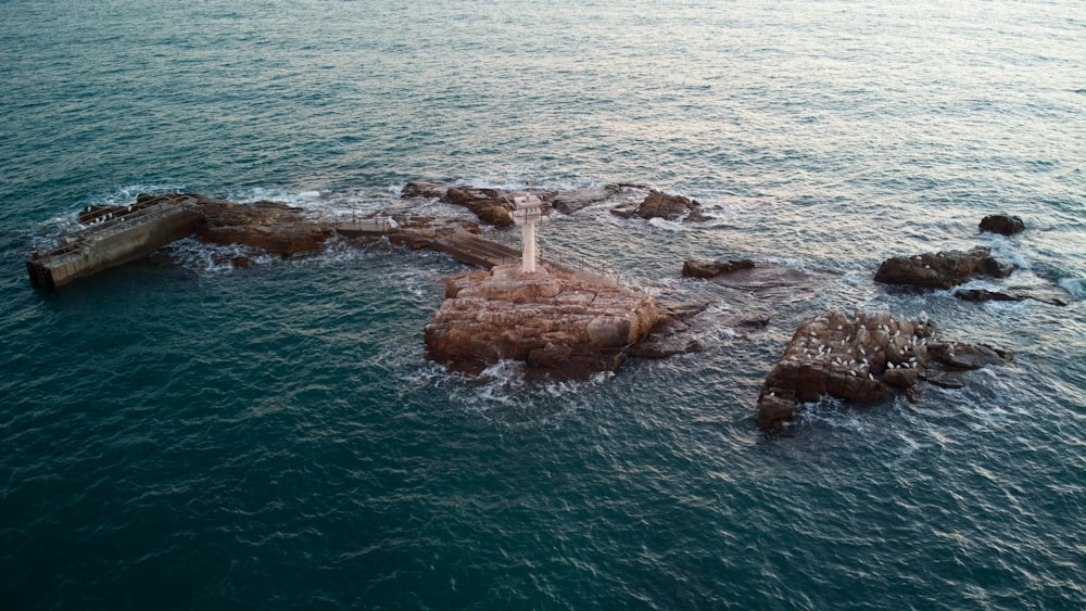 brown rock formation on body of water during daytime