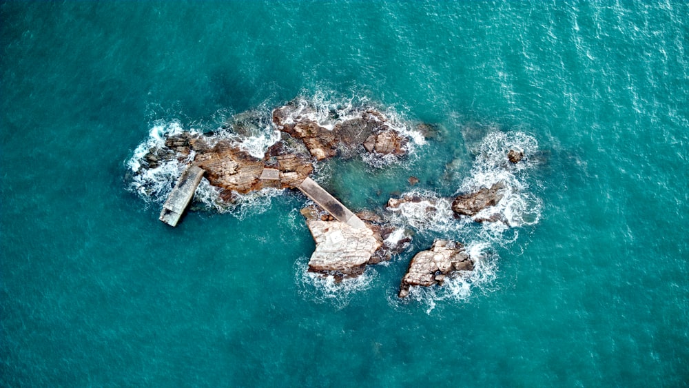 aerial view of white and brown rocks on body of water during daytime