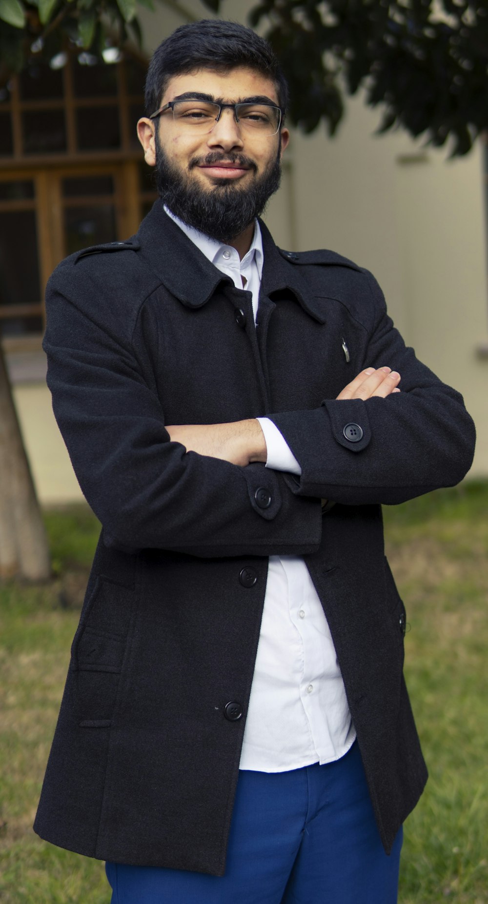 uomo in cappotto nero in piedi sul campo di erba verde durante il giorno