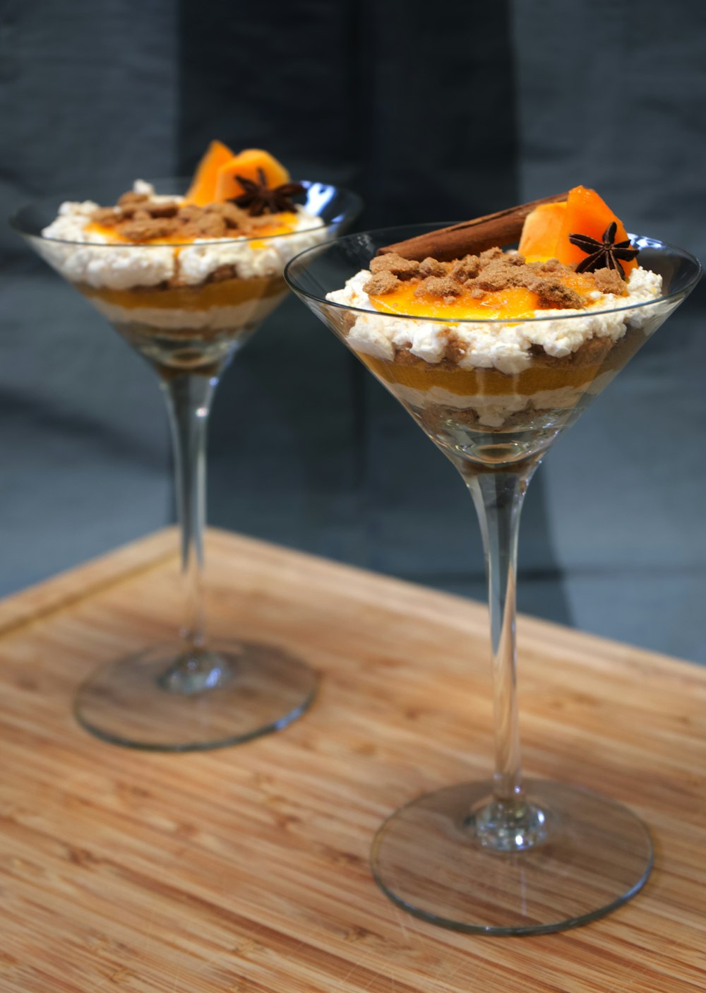 clear cocktail glass with orange and white cream on brown wooden table