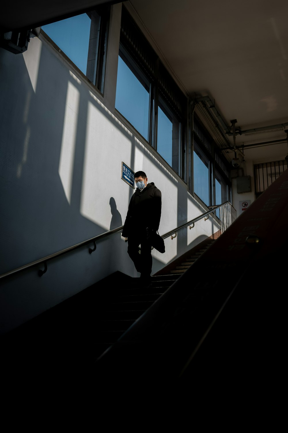 man in black jacket walking down the stairs