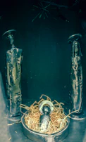 A modern nativity scene combining glass and metal elements with warm lighting.