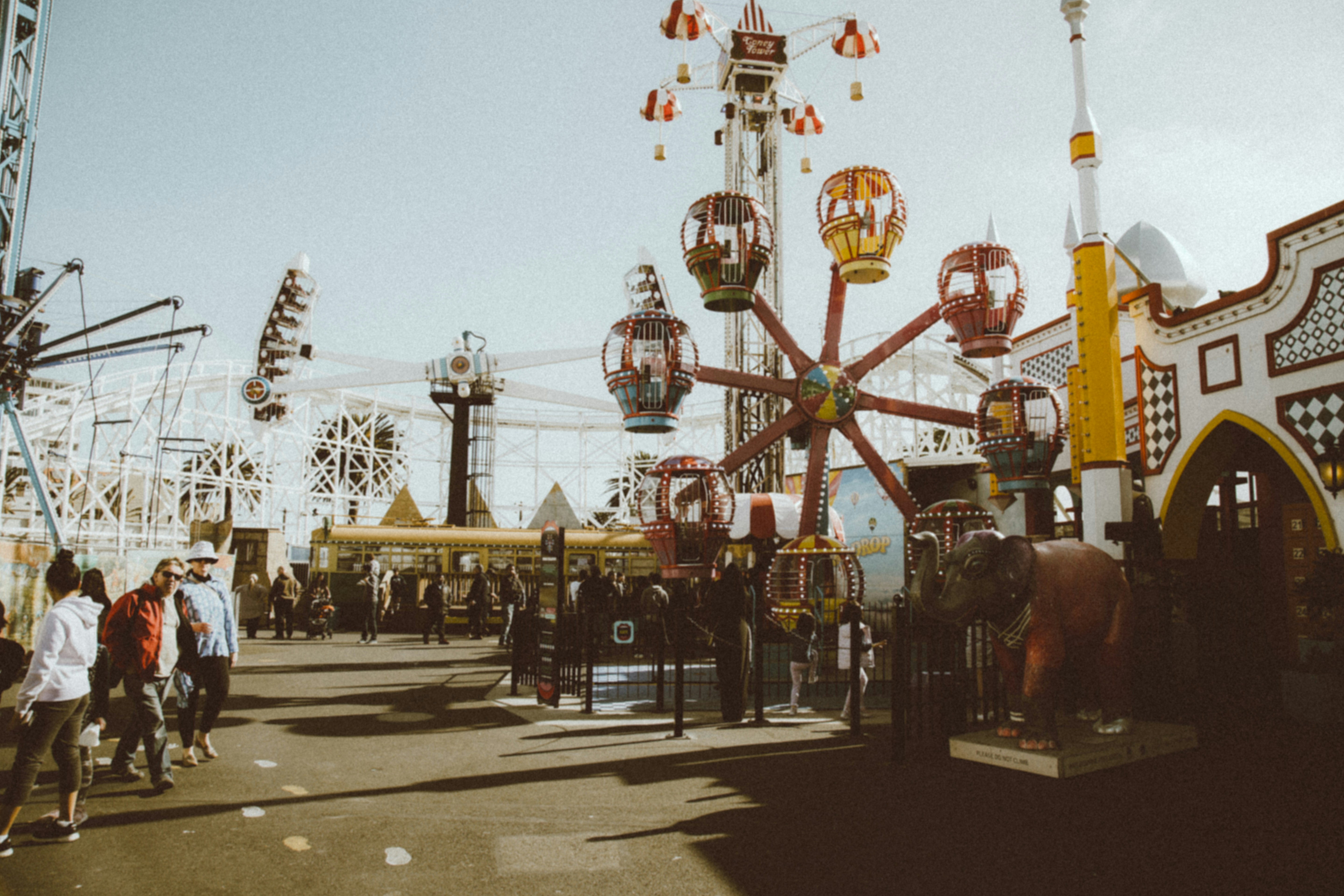 People walking beside the rides of an amusement park in Melbourne Australia