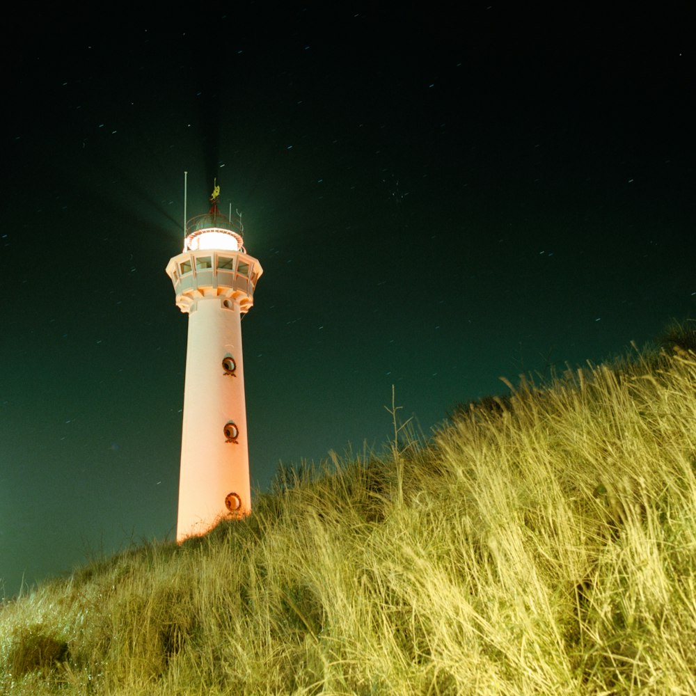 red and white lighthouse under blue sky during night time