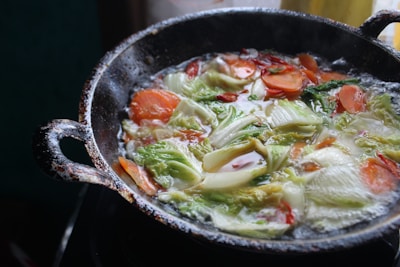 Close-up of a cast iron skillet with fresh vegetables ready to cook.
