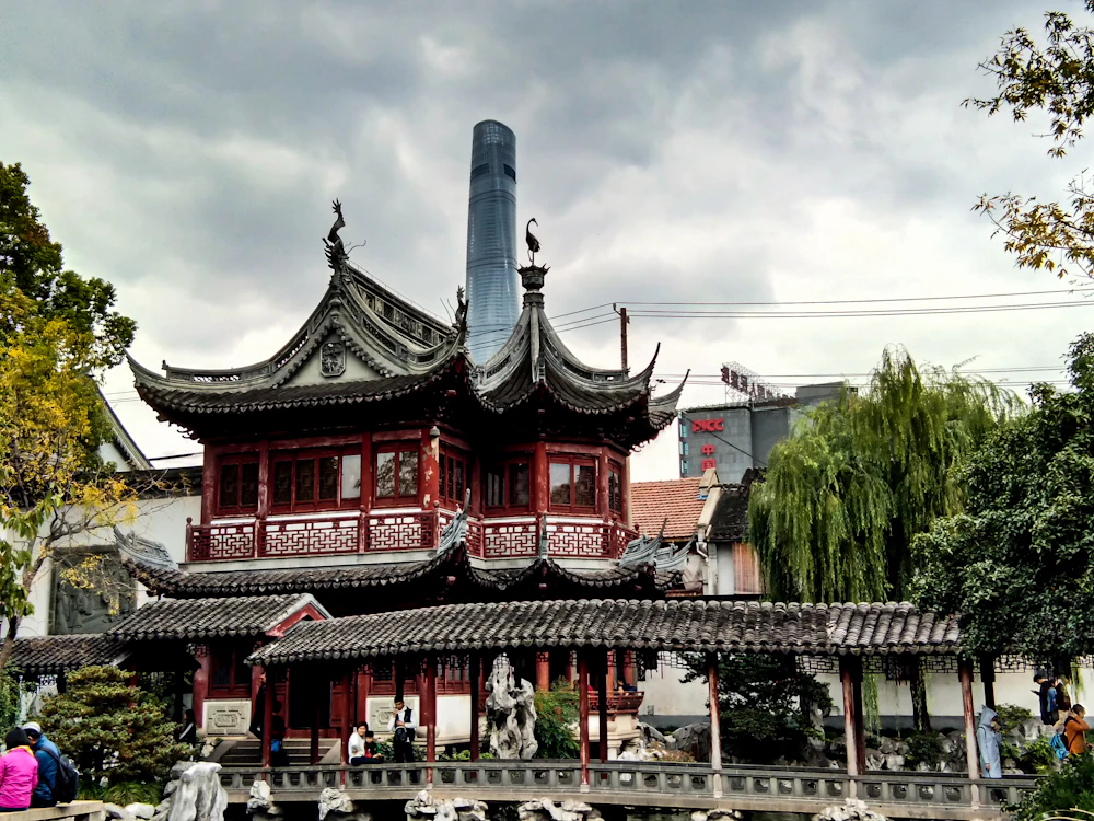 Yu Garden's classical pavilions with the Shanghai Tower rising behind