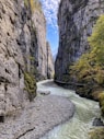 river between rocky mountains under blue sky during daytime
