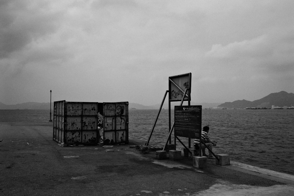 grayscale photo of a black metal frame on a beach