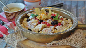 Traditional Romanian dessert papanasi topped with sour cream and jam, presented on a ceramic plate