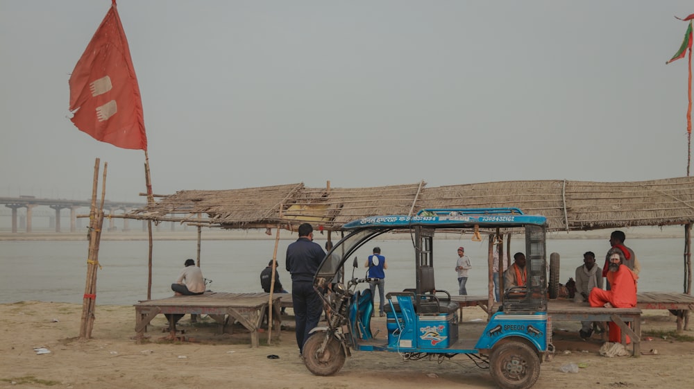 Rickshaw automático azul y negro en muelle de madera marrón durante el día