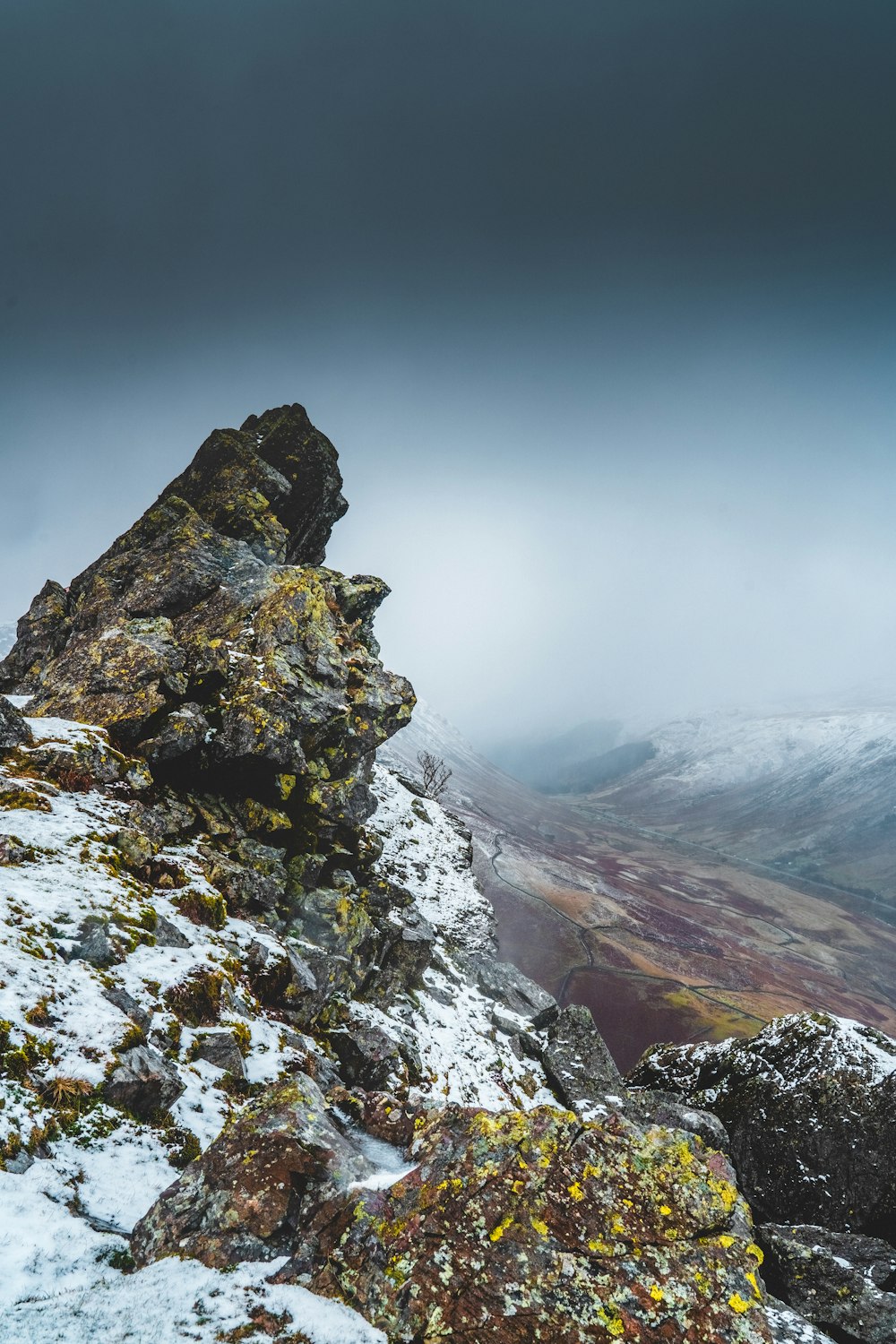 rocky mountain covered with snow under gray sky