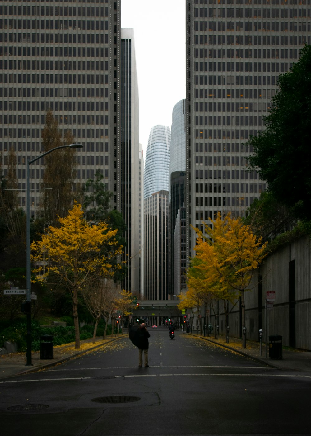 person in black jacket walking on sidewalk during daytime