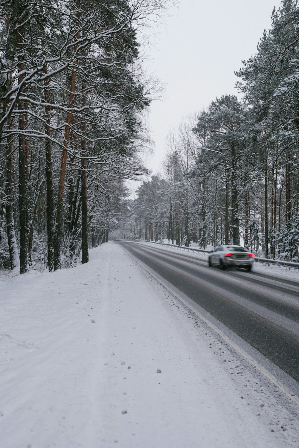 Voiture noire sur route recouverte de neige pendant la journée