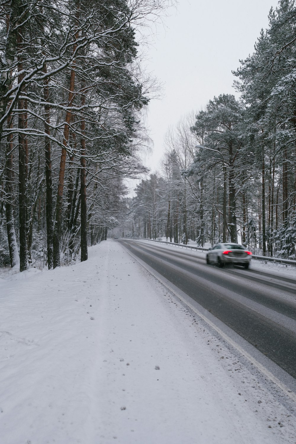 black car on road covered with snow during daytime