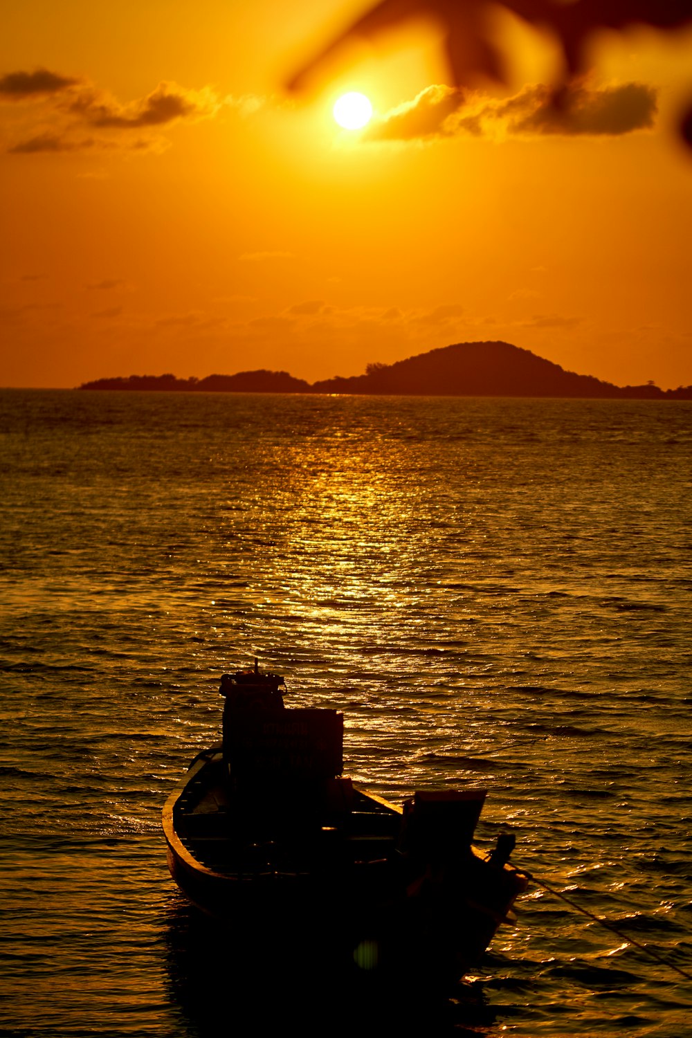 Silhouette von zwei Personen, die bei Sonnenuntergang auf dem Boot fahren