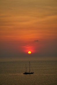 silhouette of person standing on beach during sunset