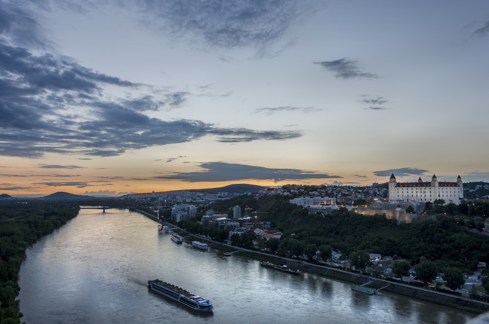 body of water near city buildings during sunset