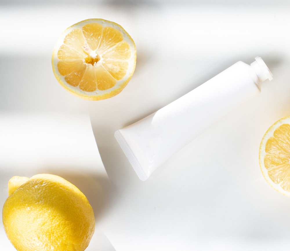 sliced lemon beside white ceramic container