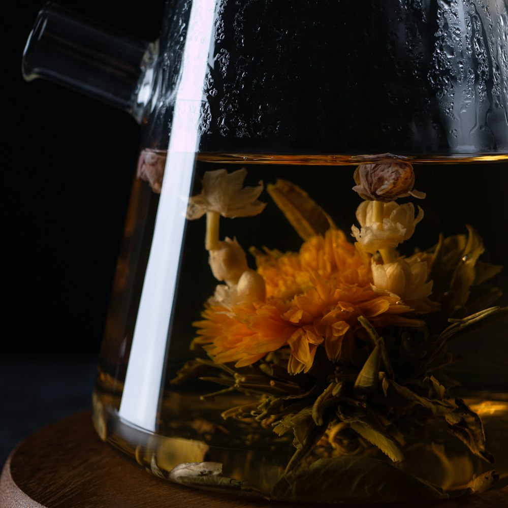 yellow flowers in clear glass jar