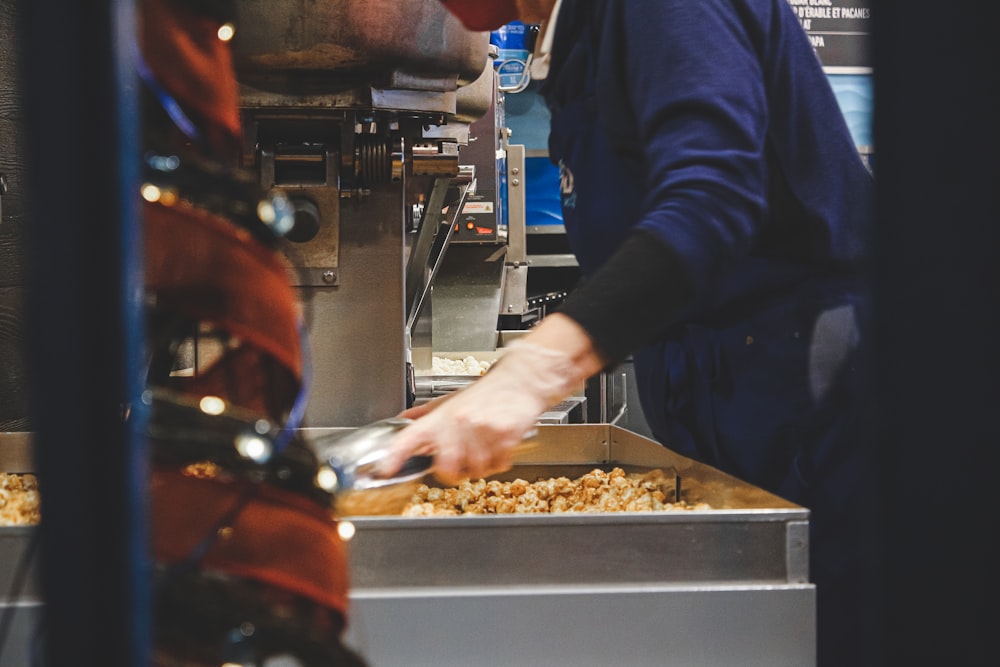 person in blue long sleeve shirt holding brown food