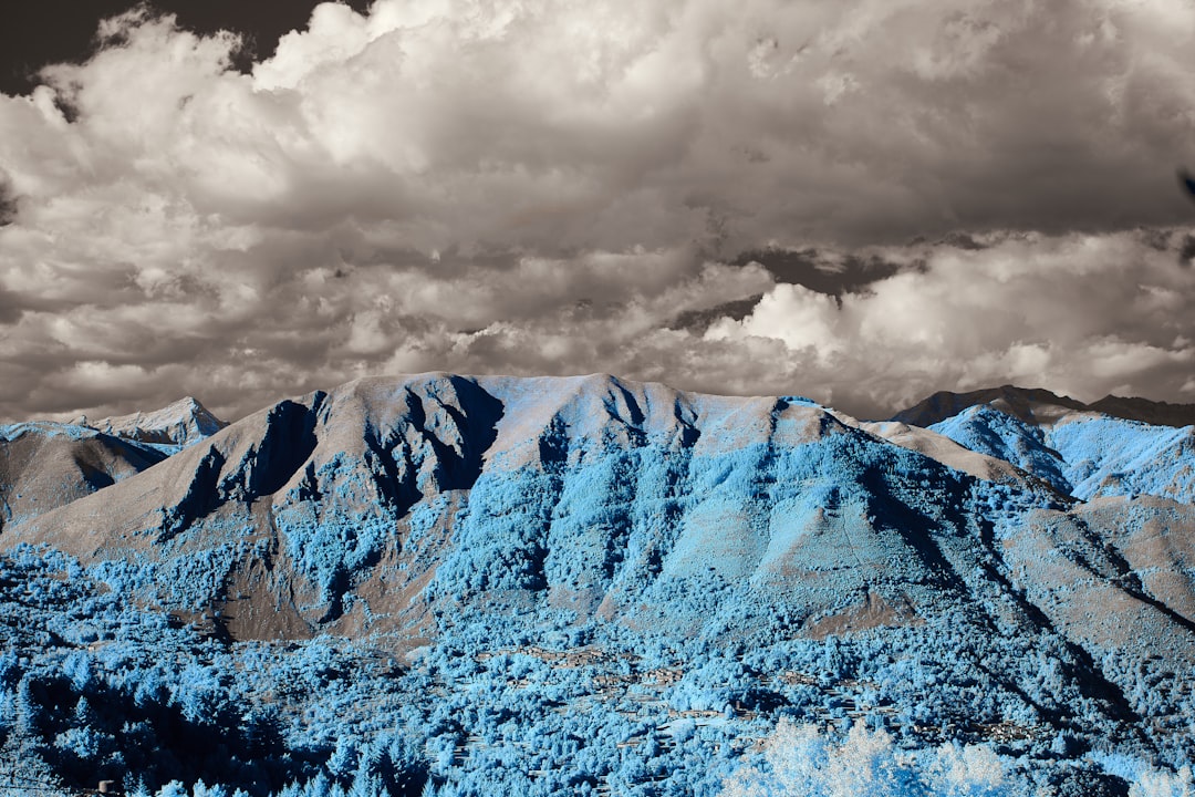 brown and white mountains under gray clouds