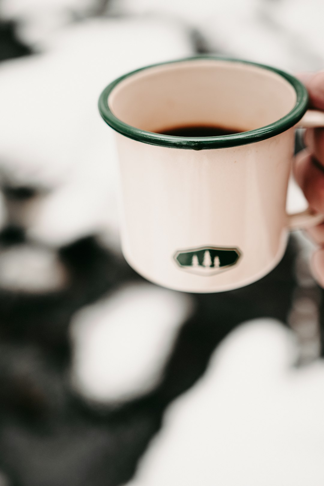 white and blue ceramic mug with brown liquid