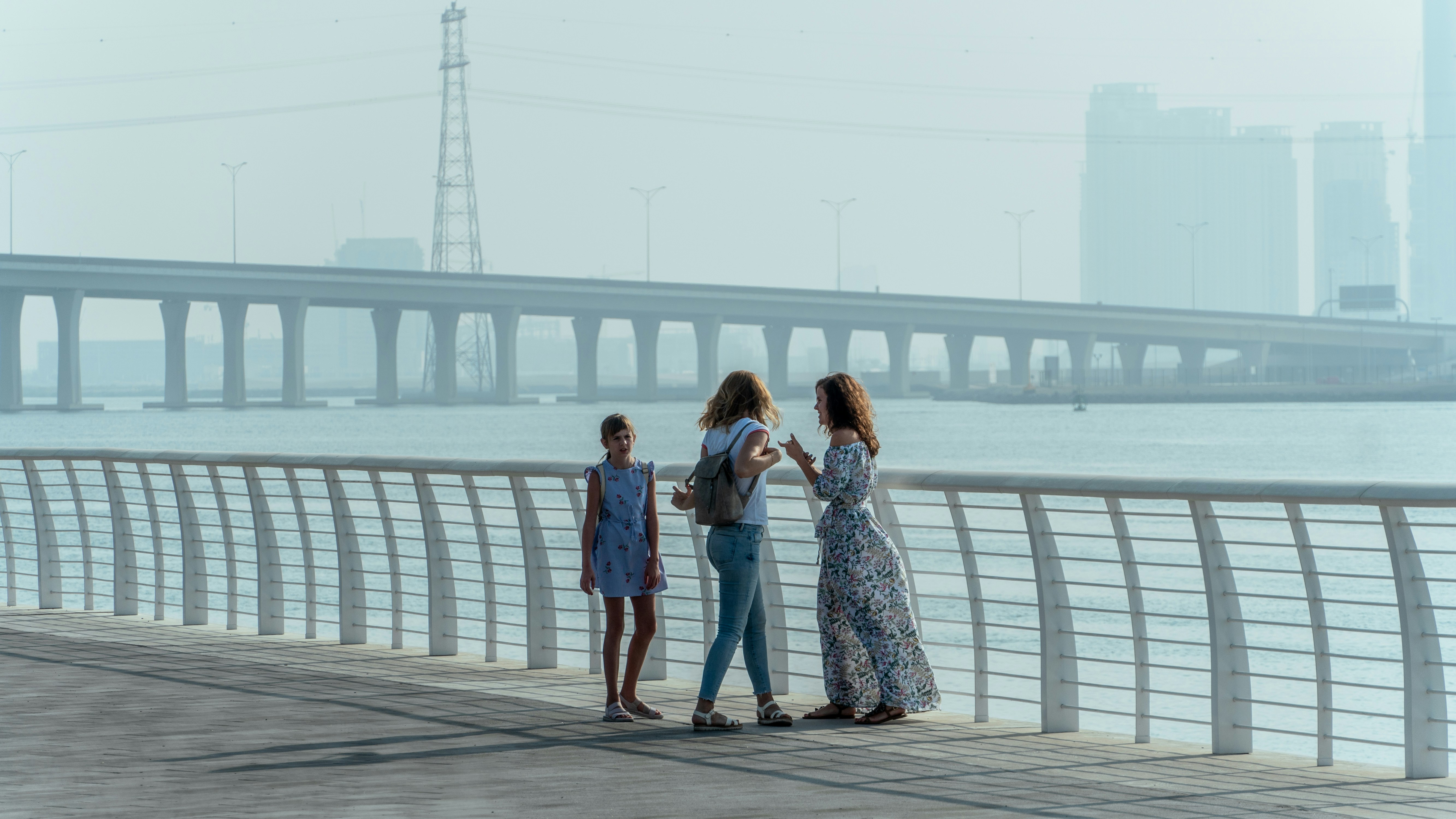 2 women standing on wooden dock during daytime