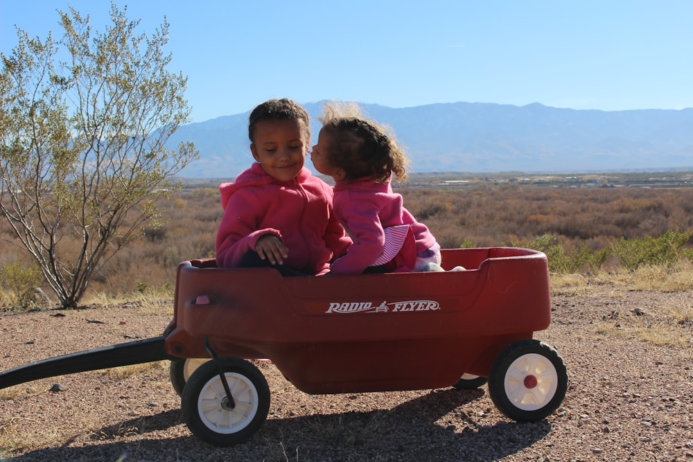 girl in pink jacket riding red and black cart