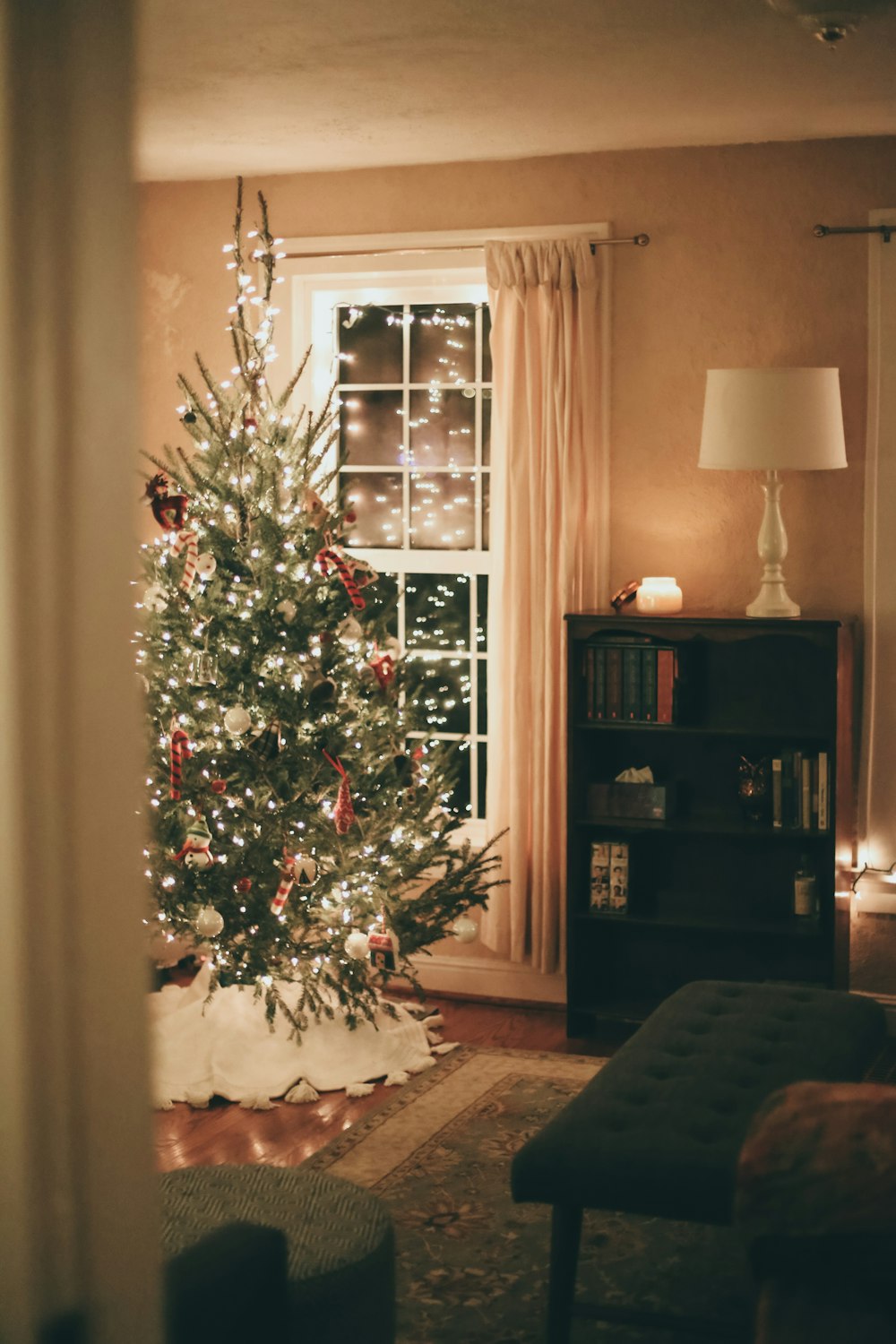 green christmas tree with baubles near brown wooden shelf